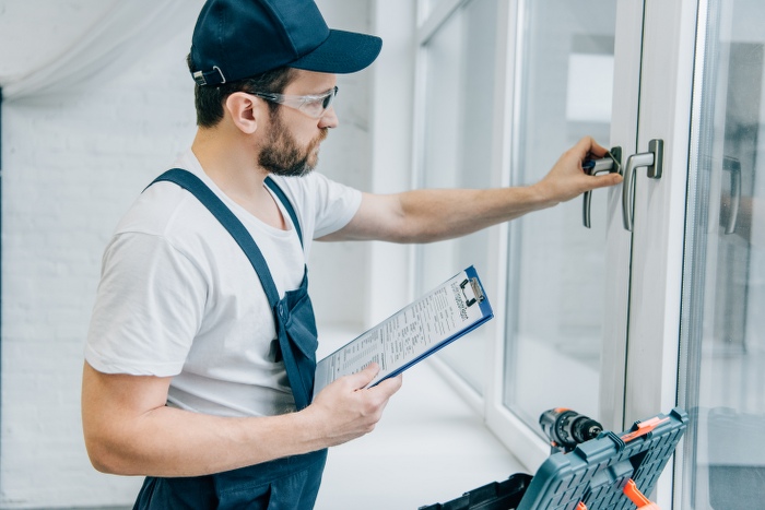 handyman checking window handle