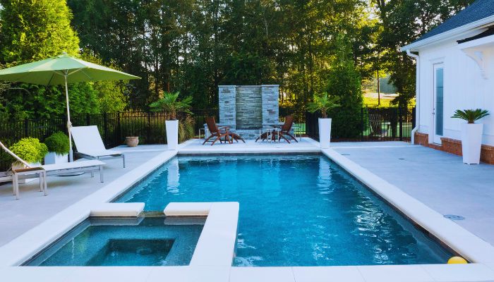 pool with chair beside it and umbrella